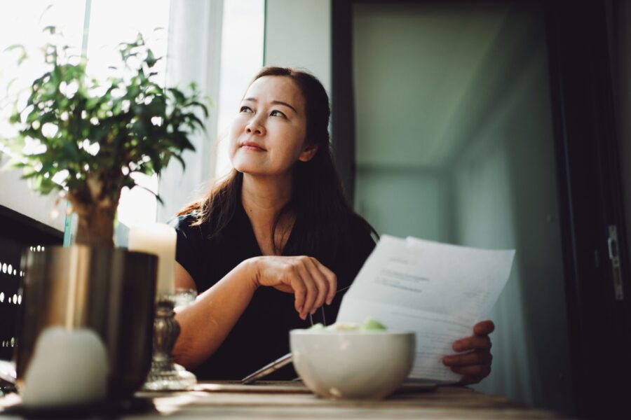 Asian senior woman working at home with a laptop.