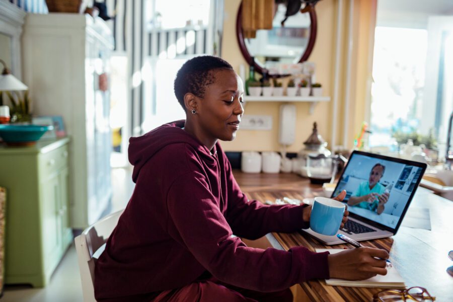 Close up of a young woman consulting with her doctor online on her laptop