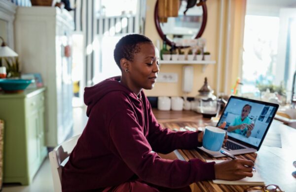 Close up of a young woman consulting with her doctor online on her laptop
