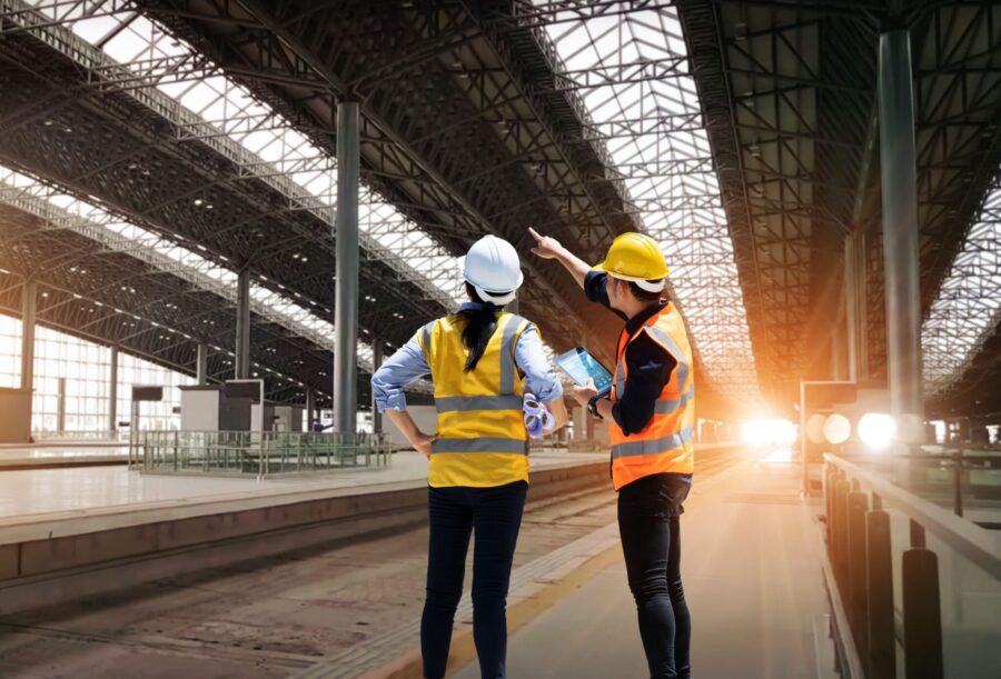 Engineers technician team checkup and analyzing an unfinished on railway station construction project with software and blueprint, Design and plan construction, Teamwork.