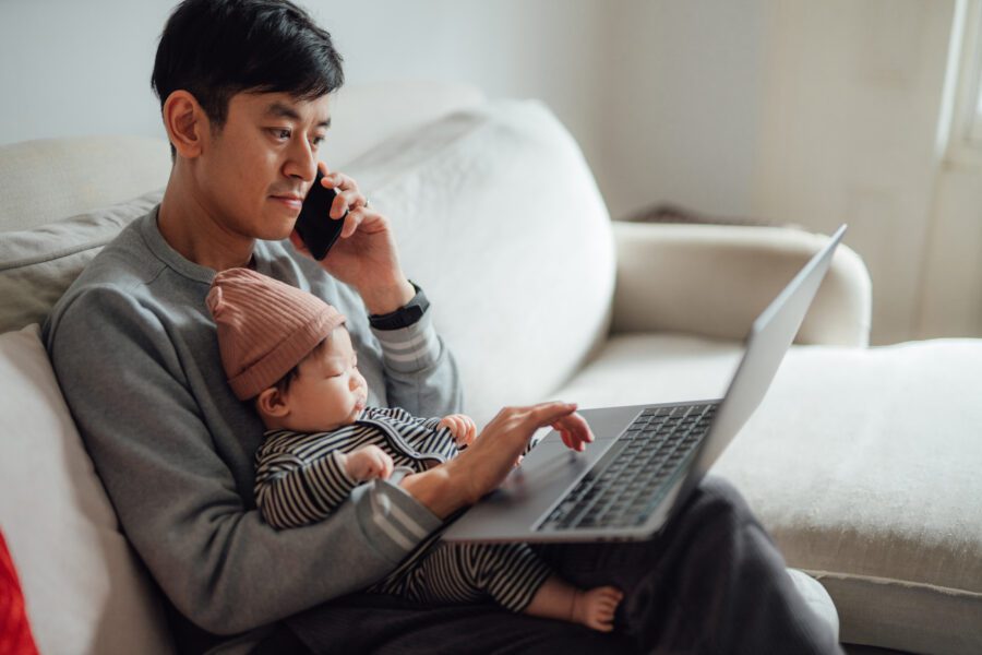 Businessman working from home while taking care of his baby.