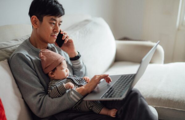 Businessman working from home while taking care of his baby.