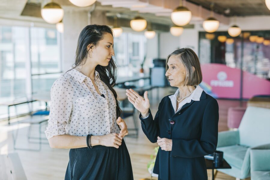 Younger business woman listening to her colleague.