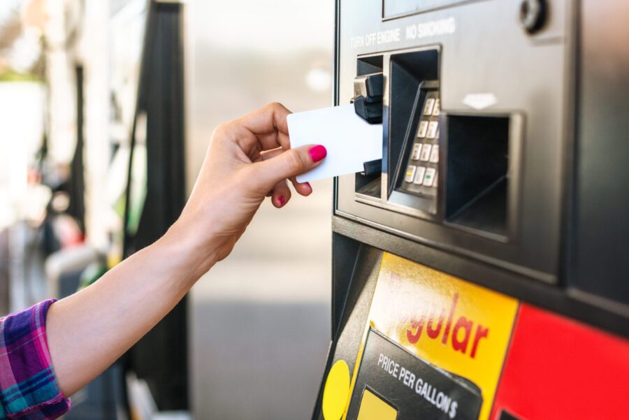 Female hand paying the fuel with credit card at the gas station.