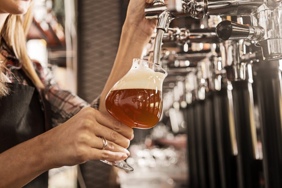 Hand Of A Female Bartender On A Beer Tap In Bar