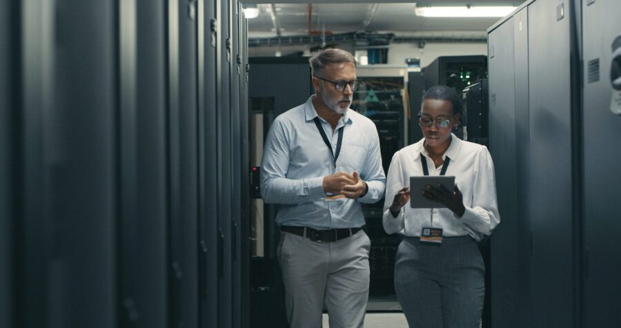 Shot of a man and woman using a digital tablet while working in a data centre