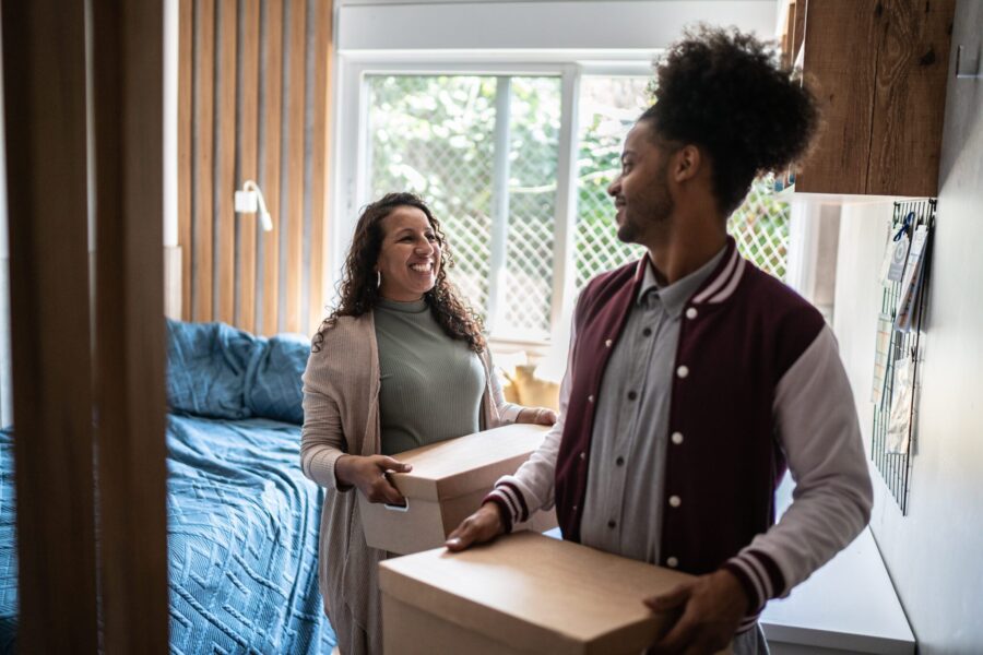 Mother helping son carrying moving boxes to move out from parent's home