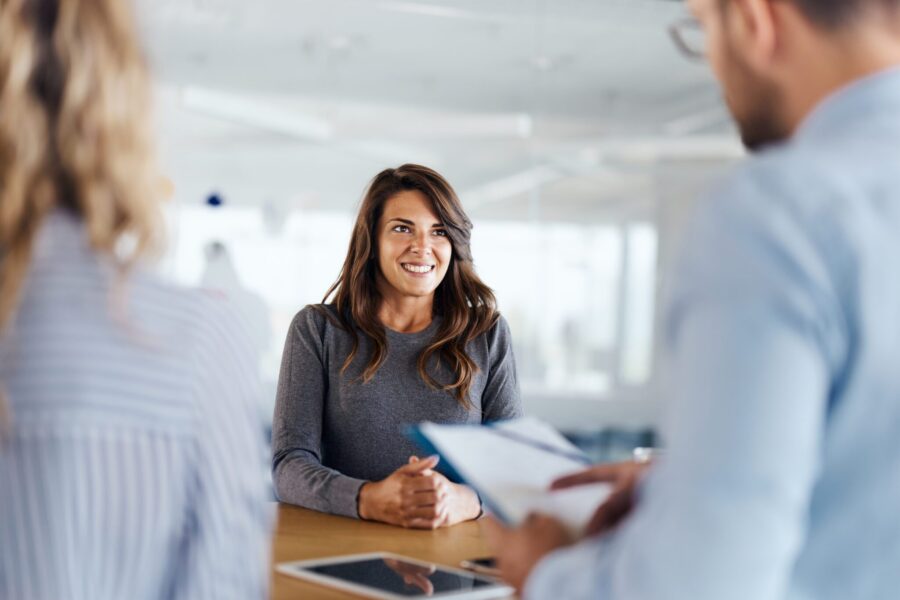 Young female candidate talking to human resource team during a job interview in the office.