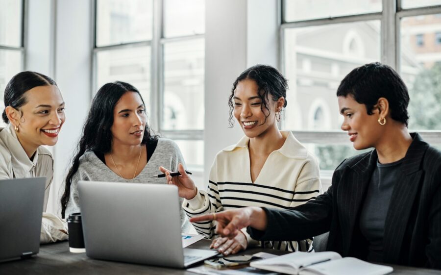 Business women, diversity and professional meeting in office work on sales growth, corporate strategy and planning digital advertising peoject on laptop. Female empowerment, advertising and marketing