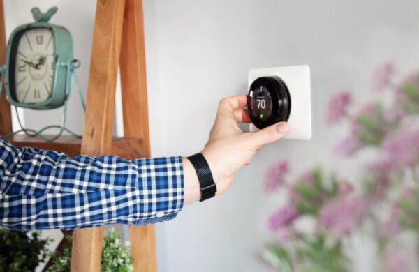 Man is Adjusting a temperature on the thermostat in the living room.