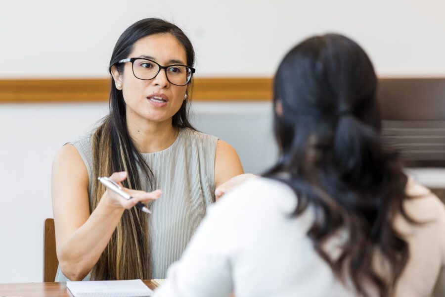 two women talking at a desk