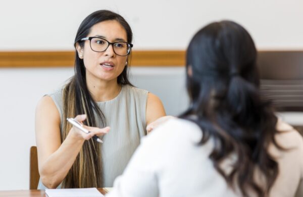 two women talking at a desk