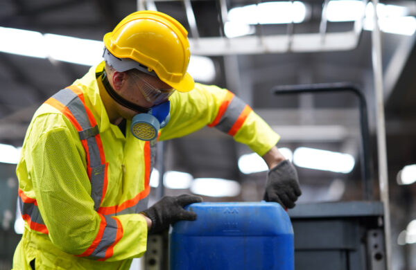 Factory worker wearing respirator masks for protection toxic substances while open the solution tank working in hazardous environments, Health and safety