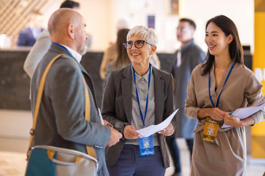 Business people socializing in the lobby of a hotel before a conference event starts