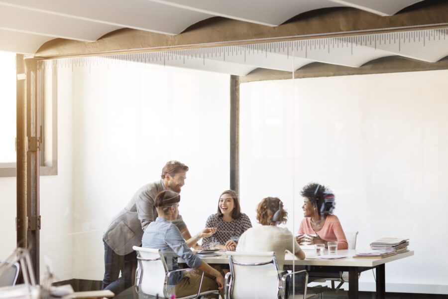 Happy young business colleagues in board room at office