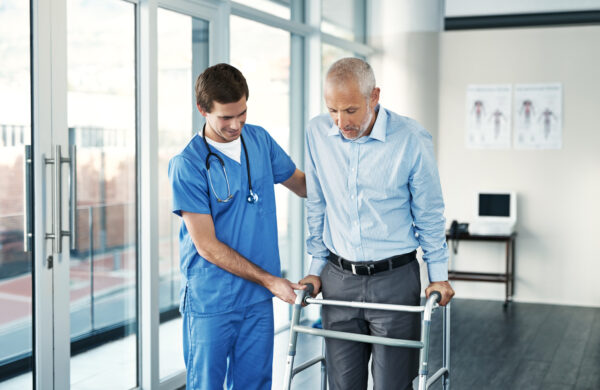 Shot of a male nurse assisting a senior patient with a walker