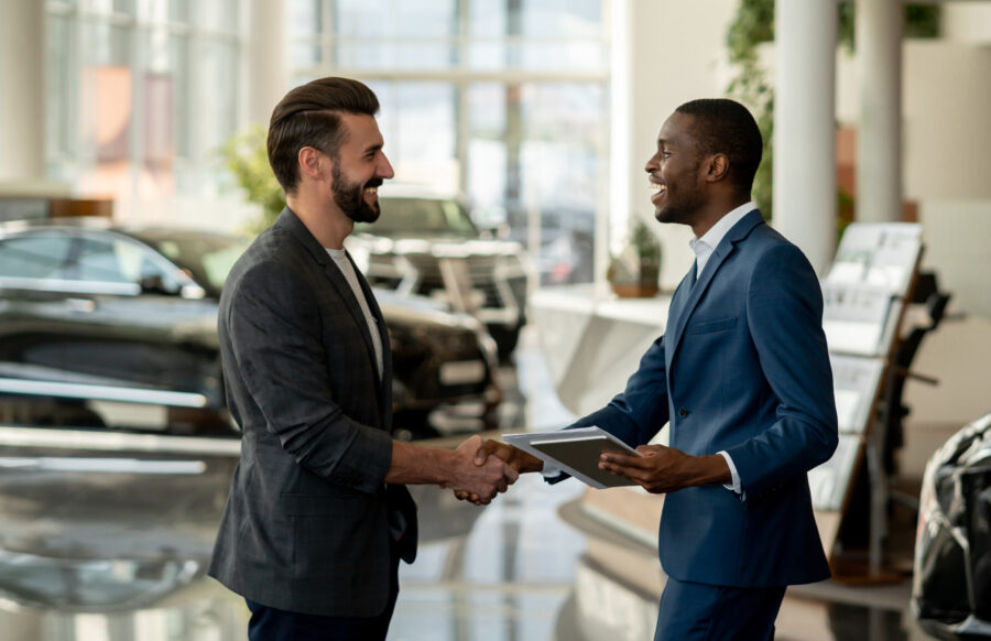 Customer Closing A Deal With A Salesman At A Car Dealership