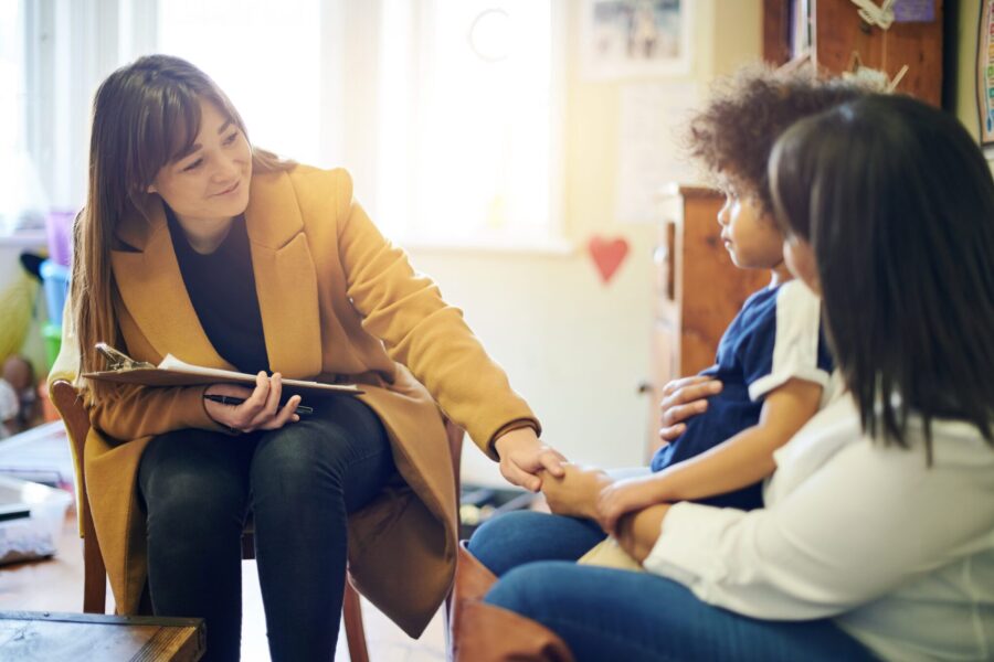 Mother, child and psychologist consultation in office for support, help and mental health. Psychology doctor, therapist and happy woman, mom and boy in family counselling, therapy and advice talking