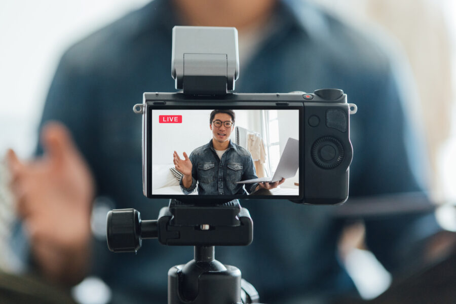Young Man Vlogging Through Video Camera At Home