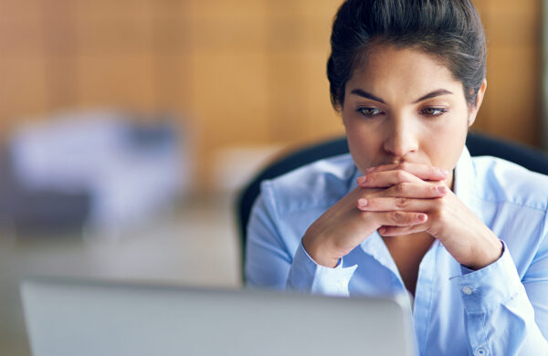 Shot of a young businesswoman looking stressed while working on her laptop
