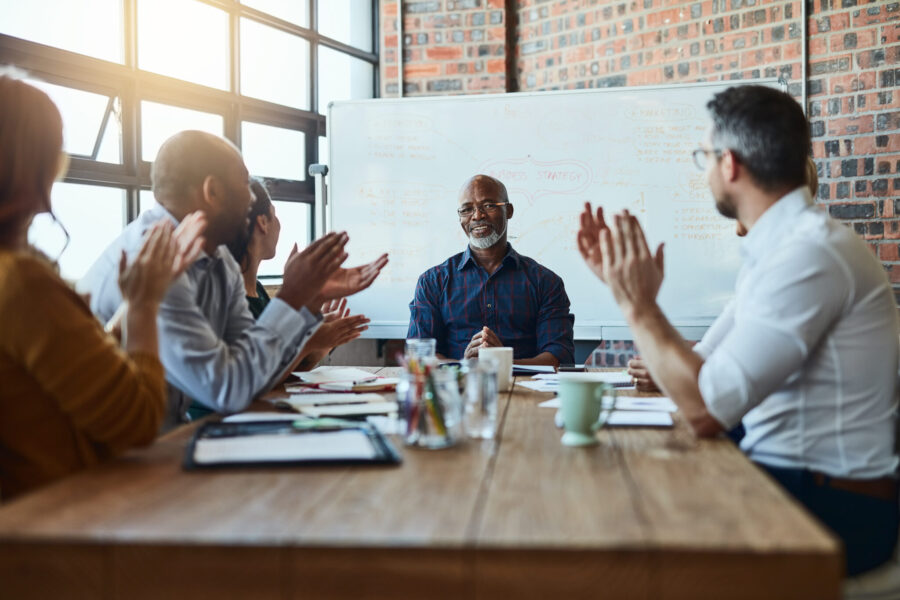 Cropped shot of a group of businesspeople in the office applauding a colleague after a successful group meeting