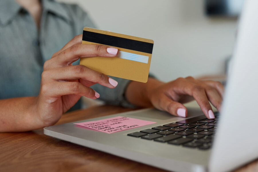 Closeup of an unrecognisable woman using a laptop and credit card at home