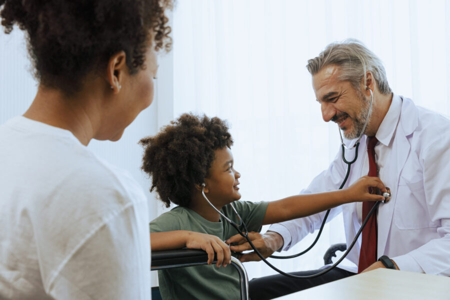 Doctor using stethoscope take the pulse to young boy patient in medical examination room for healthcare and medicine industry concept.