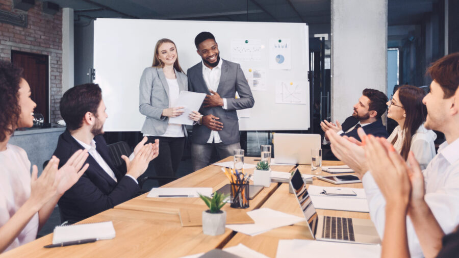 Boss welcoming new employee and representing to colleagues at meeting