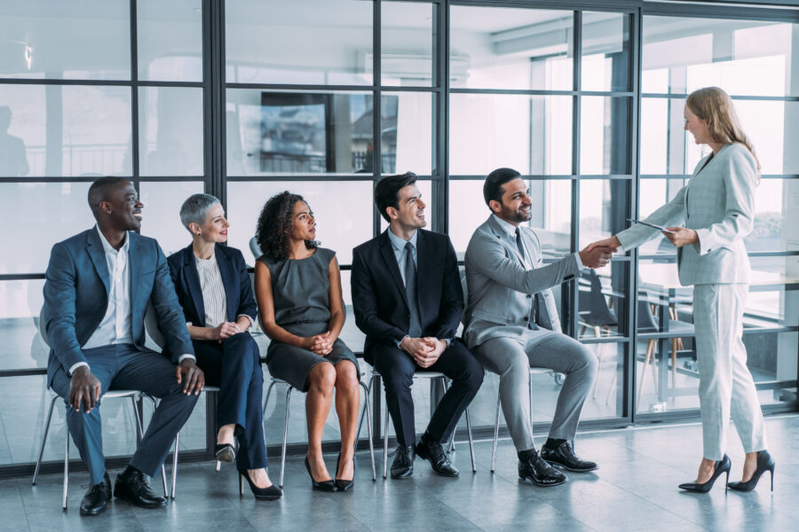 HR manager handshaking with candidate at job interview.