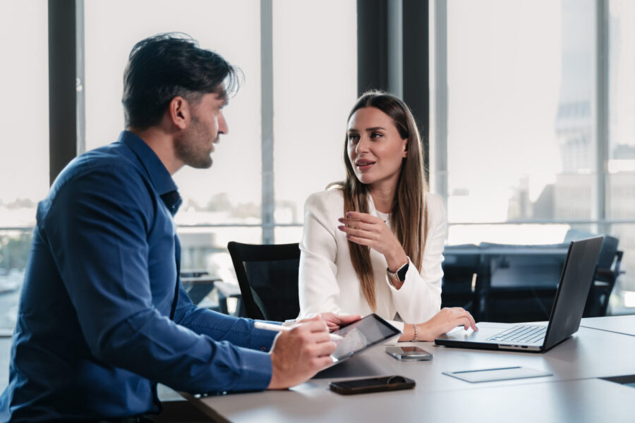 Businessman and businesswoman working together on a laptop and digital tablet in the office