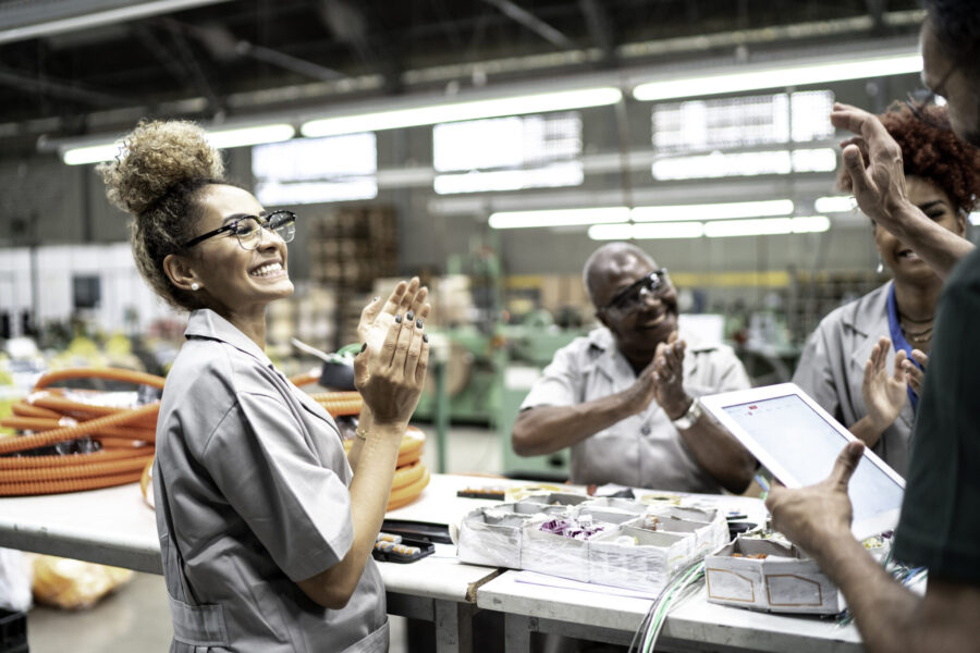 Happy team celebrating in a factory