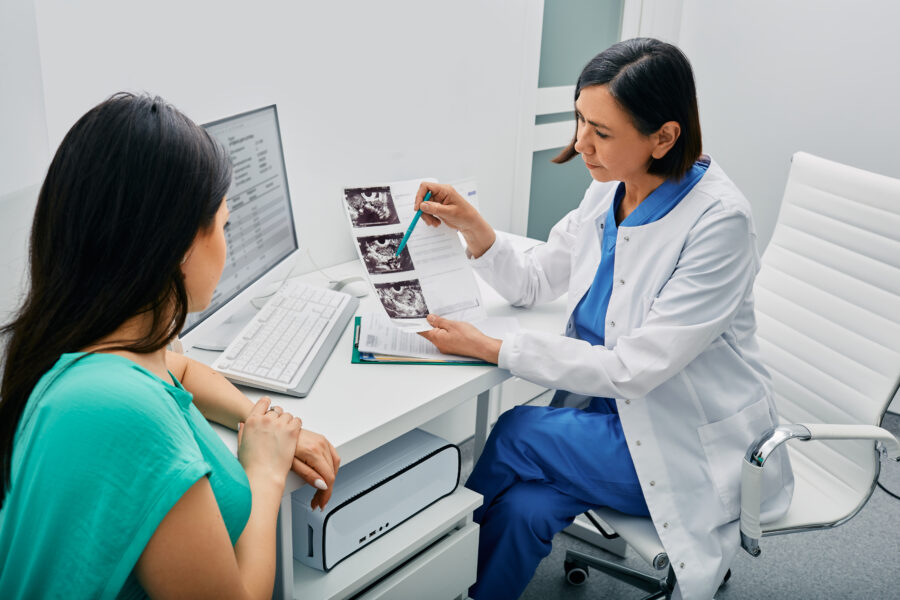 Doctor and woman patient is talking in gynecological office during visit at gynecology office. Consultation of gynecologist