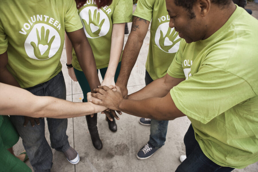 Volunteers Holding Hands In Circle