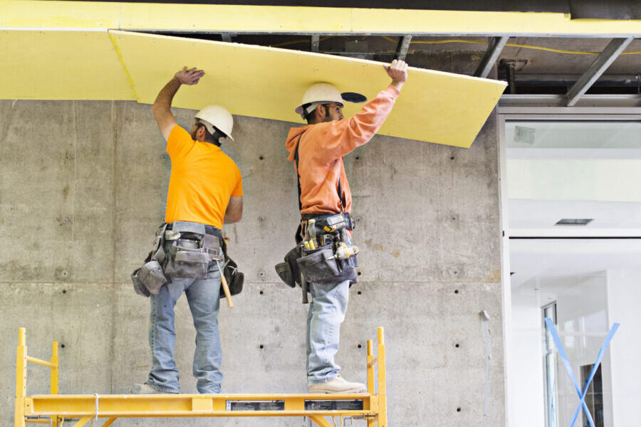 Construction workers applying insulation