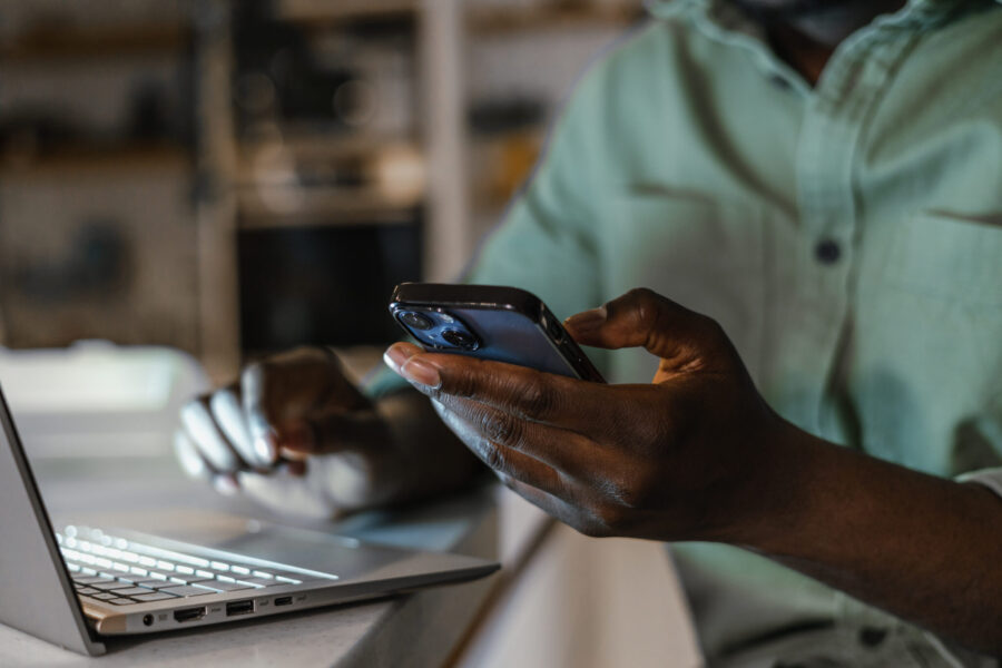 Close-up photo of African American male hands typing on a laptop keyboard