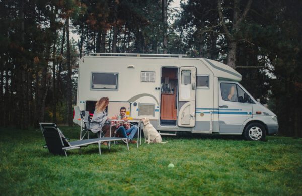 An idyllic photo of a young loving couple camping in nature with their dog