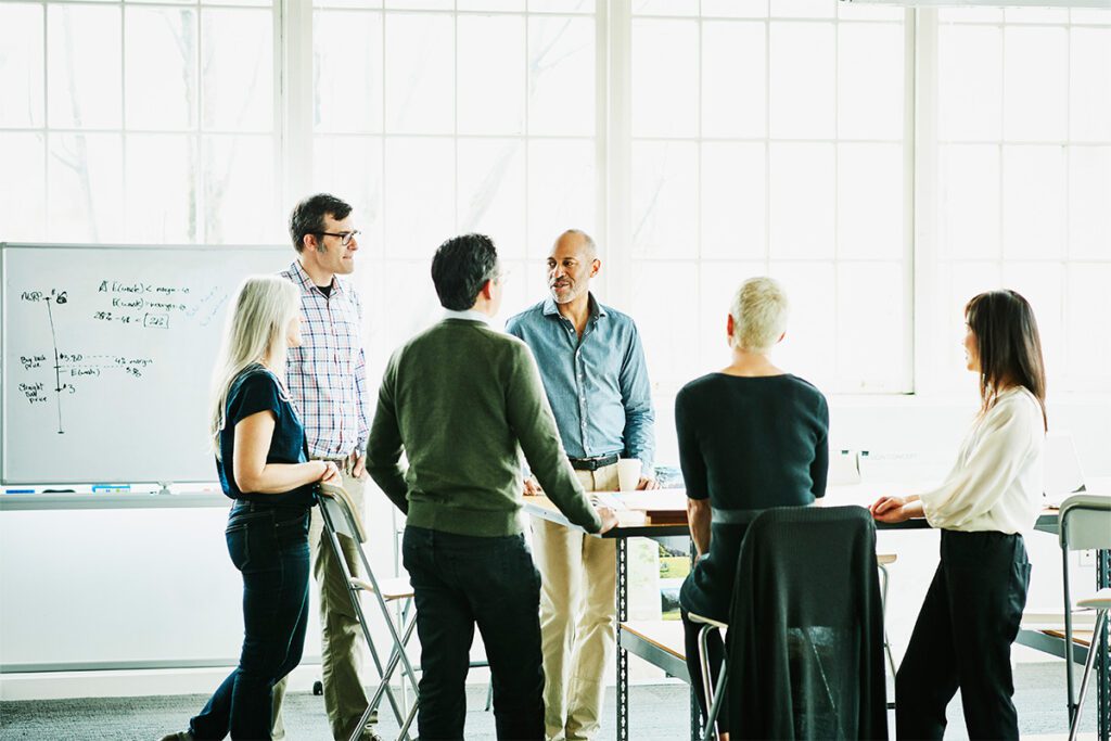 Group of colleagues having a discussion as part of a business meeting in the office