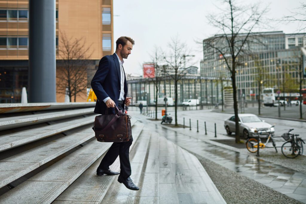 Adult man leaving work at the office, walking and holding a briefcase