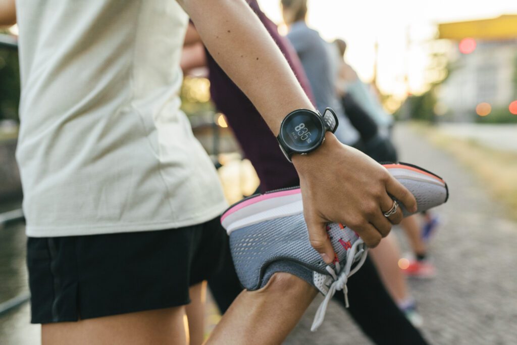 A close up of a woman stretching her legs before going on a run through the city for exercise