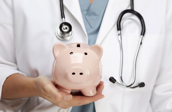 Female Doctor with Stethoscope Holding Piggy Bank