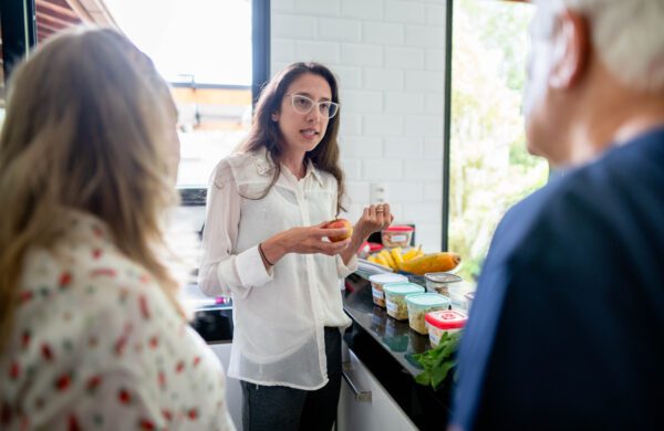 Young nutritionist discussing meal planning and nutrition with several people during a diet consultation