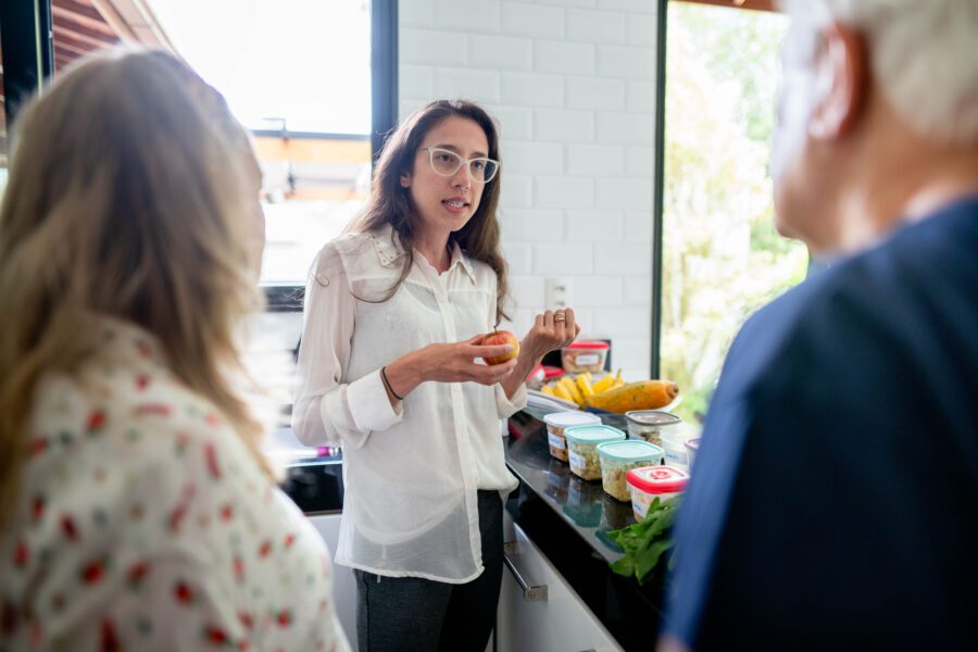 Young nutritionist discussing meal planning and nutrition with several people during a diet consultation