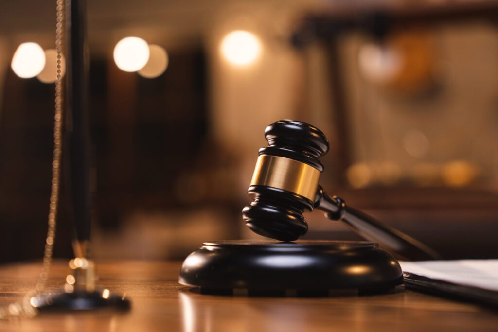 Judge gavel resting on the table with blurry books in the background