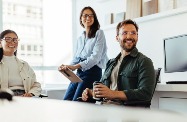 Group of happy business professionals listening to a discussion in an office