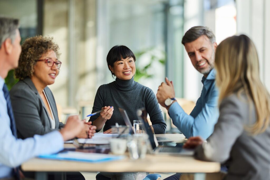 Group of happy multiracial entrepreneurs communicating during a meeting in the office