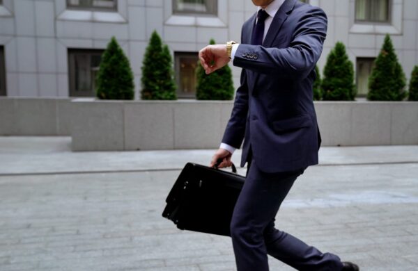 Office worker looking at watch while running late for work
