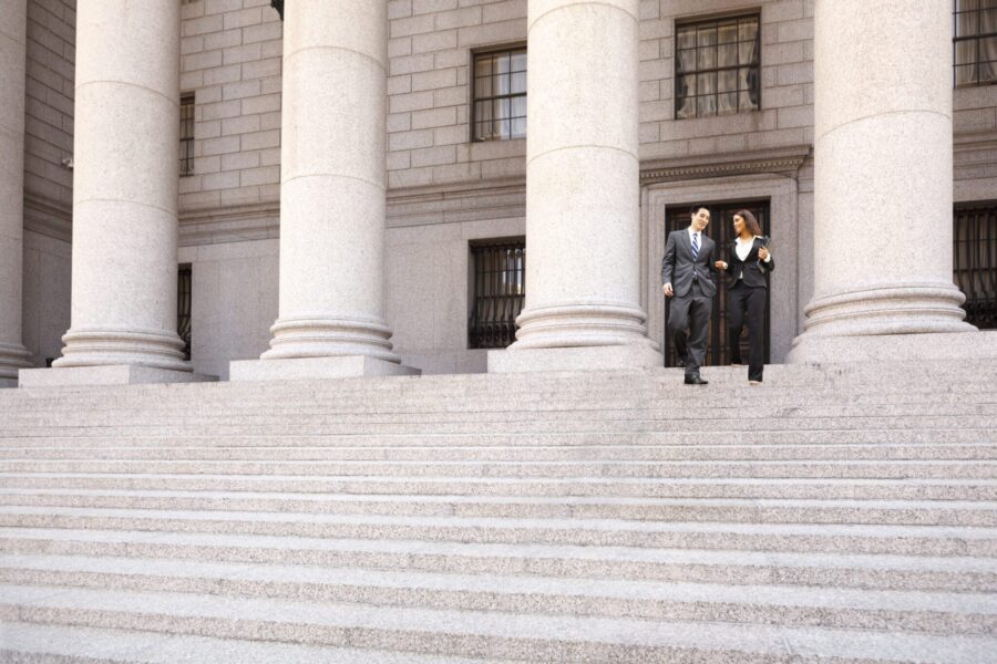 Lawyer and Client Descend Courthouse Staircase