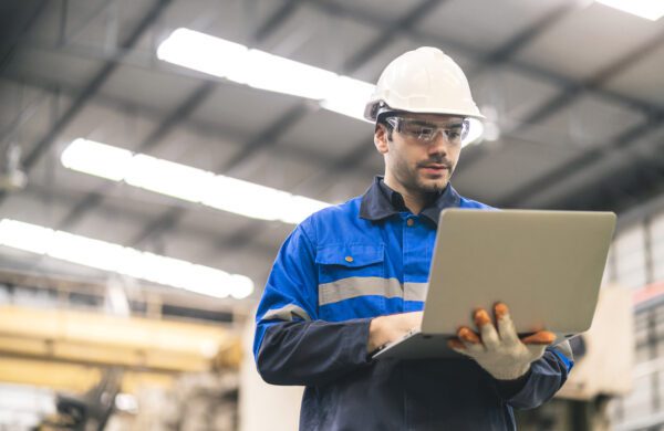 Professional engineer performing workplace inspection and safety check and documenting findings on computer