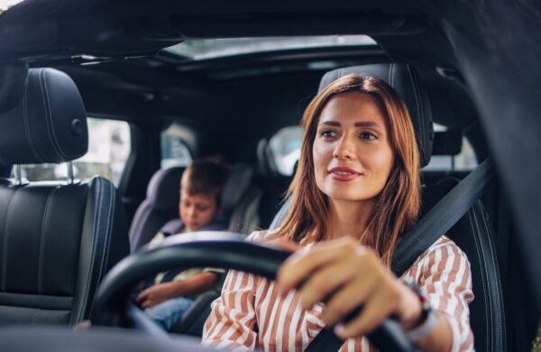 Mother drives her young son to school in the family car