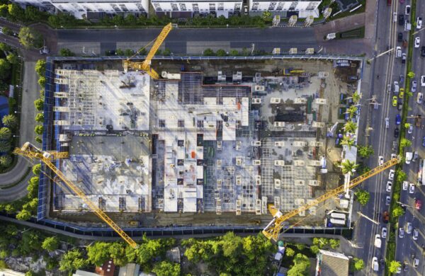 Aerial view of large construction project site with multiple cranes